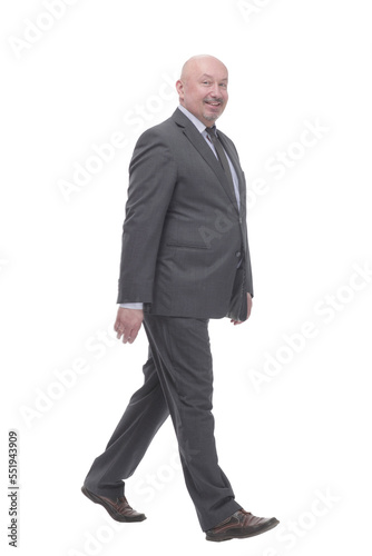 Mature business man striding forward .isolated on a white background. © ASDF
