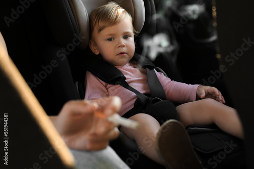 Foto Mother with cigarette and child in car, closeup