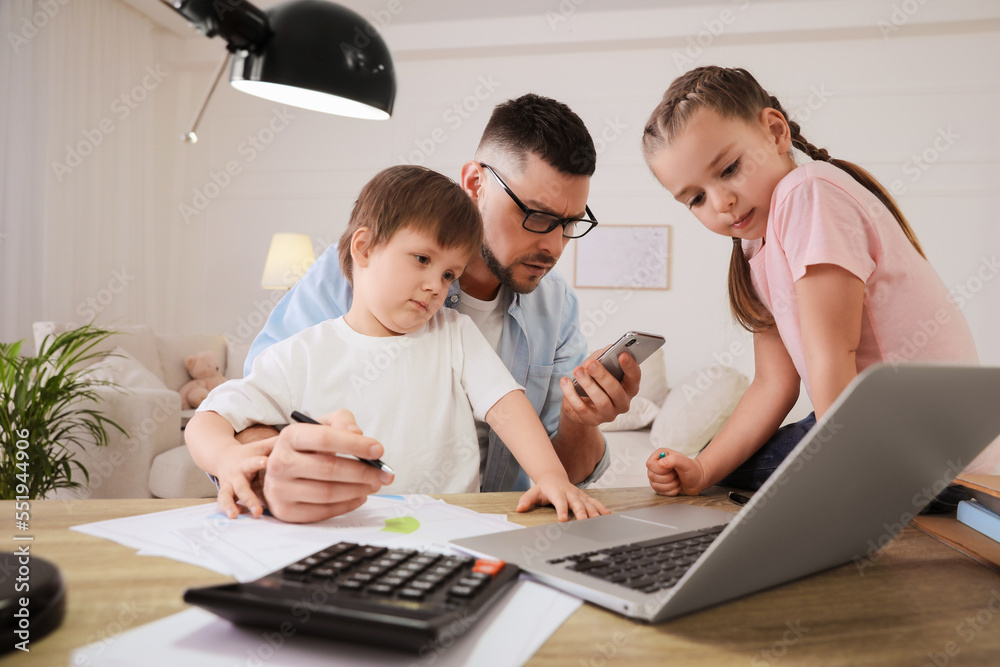 Overwhelmed man combining parenting and work at home Overwhelmed man combining parenting and work at home