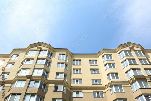 Exterior of multi storey apartment building against blue sky, low angle view
