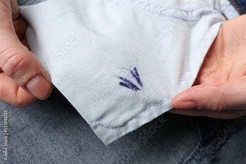 Woman holding jeans with ink stain, closeup
