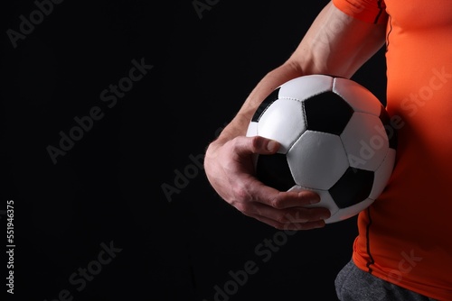 Athletic man with soccer ball on black background, closeup. Space for text © New Africa