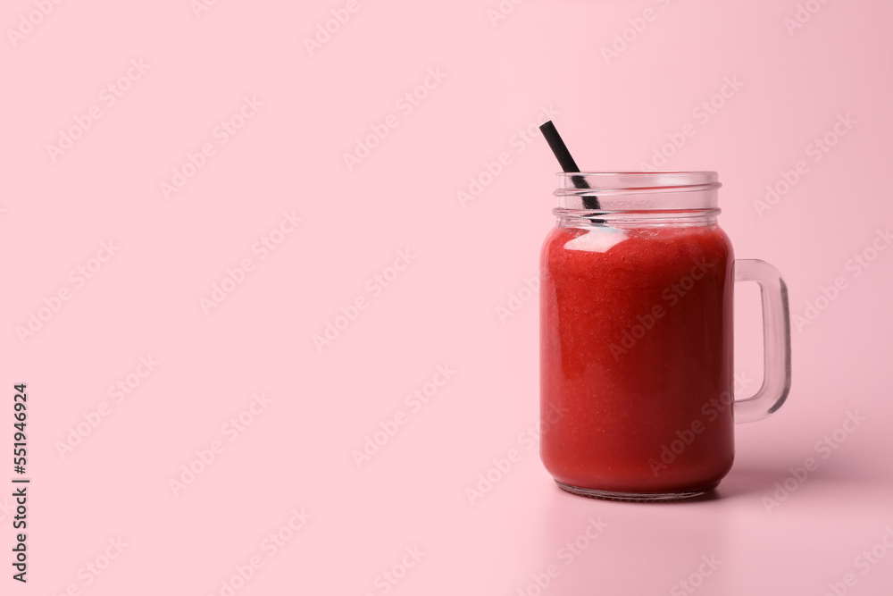 Mason jar with delicious berry smoothie on pink background. Space for text Mason jar with delicious berry smoothie on pink background. Space for text