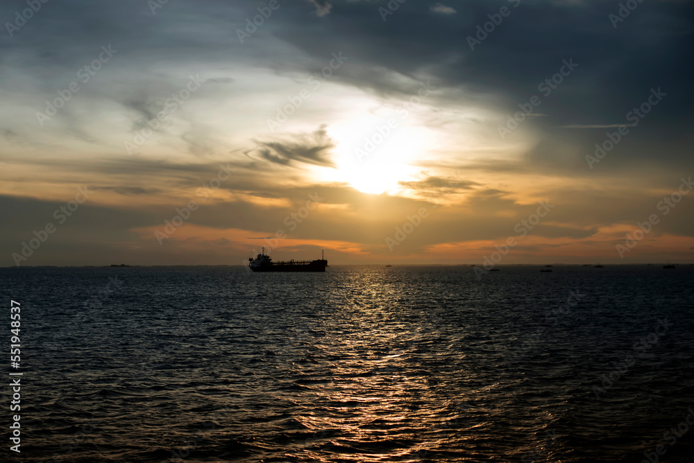 Sunset over the sea with shadows of industrial ships Sunset over the sea with shadows of industrial ships