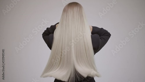 Luxurious long blonde hair in motion. Back view.