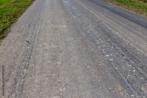 Details of a road polluted with sand and debris from fields