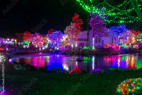 Christmas light show on the riverbanks reflecting in the calm water
