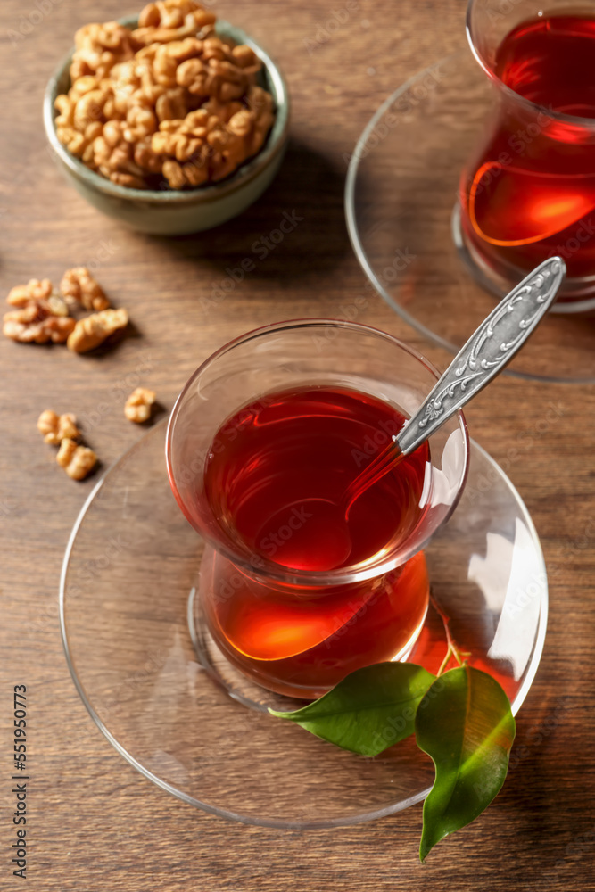 Glasses of traditional Turkish tea and walnuts on wooden table, above view Glasses of traditional Turkish tea and walnuts on wooden table, above view
