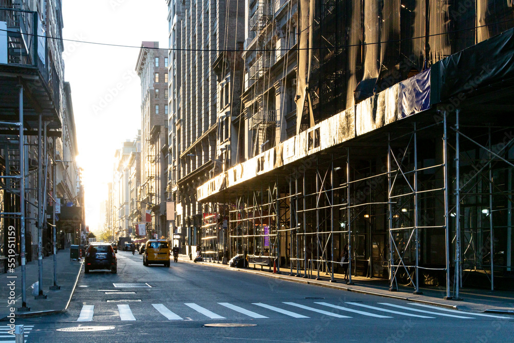 Construction scaffolding covers the buildings and sidewalks on 19th Street in Manhattan, New York City