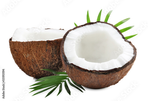 Halves of fresh ripe coconut with green leaves on white background