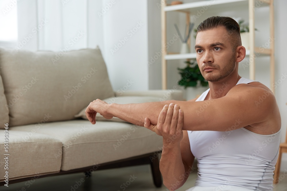 Man sports, watching tape of workout on phone and repeating exercises sports blogger with laptop training online, pumped up man fitness trainer works out at home, the concept of health and body beauty Man sports, watching tape of workout on phone and repeating exercises sports blogger with laptop training online, pumped up man fitness trainer works out at home, the concept of health and body beauty