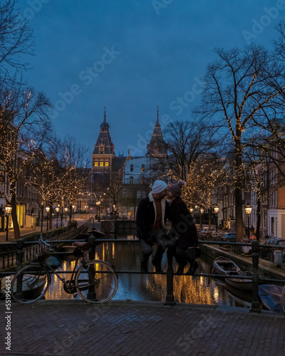 Canvas Print Amsterdam Netherlands canals with Christmas lights during December, a couple on