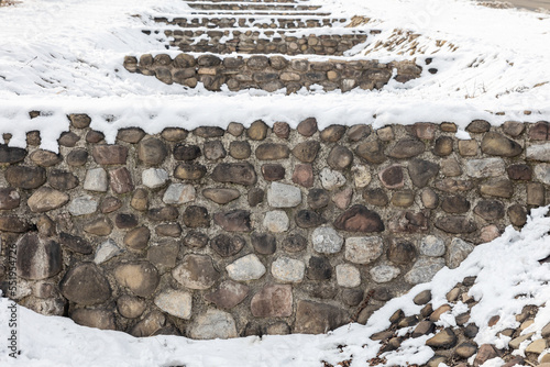 The snow covering the stone wall photo