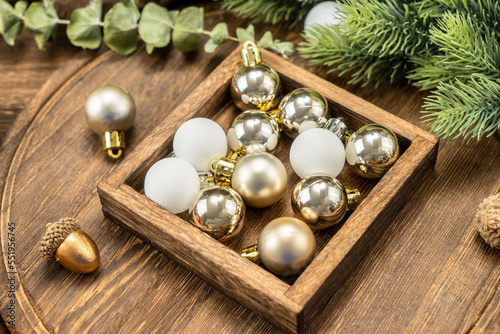 Christmas balls on wooden cutting board with Christmas decorations.