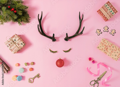 Creative Christmas composition made with horns reindeer, presents, decoration, and winter things on pastel pink background.Vacation concept.  Creative art minimal aesthetics. Flat lay, top view