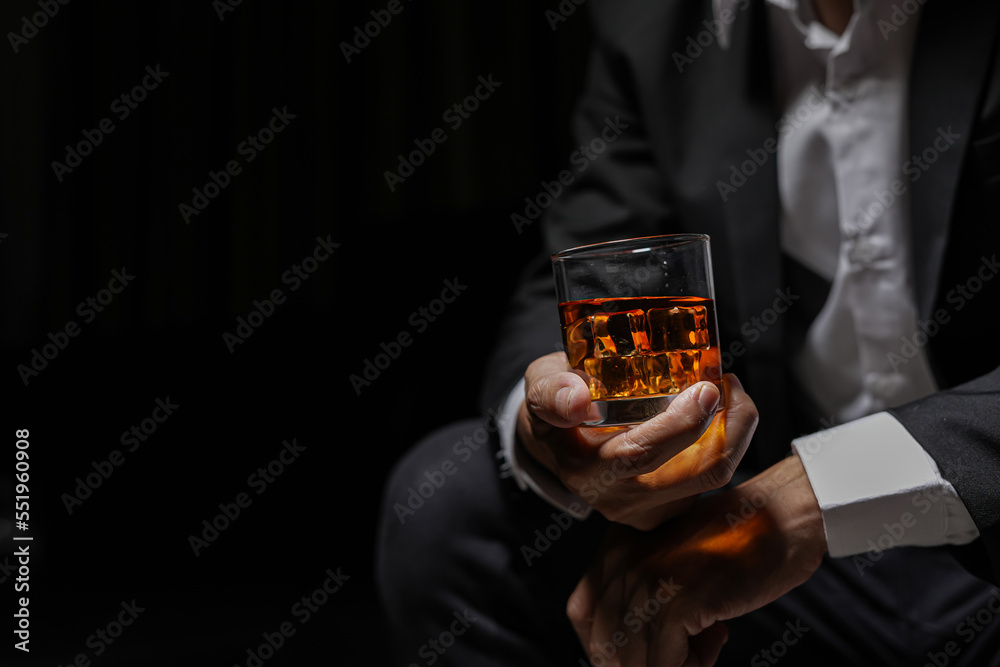 Closeup businessmen holding a glass of whiskey - obrazy, fototapety, plakaty 