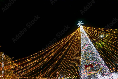 Scene of Christmas tree lighting on night time background with space for texts.