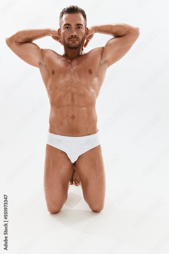 Man athletic body bodybuilder in briefs with naked torso abs full-length in the background, fitness classes. Advertising, sports, active lifestyle, competition, challenge concept. Man athletic body bodybuilder in briefs with naked torso abs full-length in the background, fitness classes. Advertising, sports, active lifestyle, competition, challenge concept.