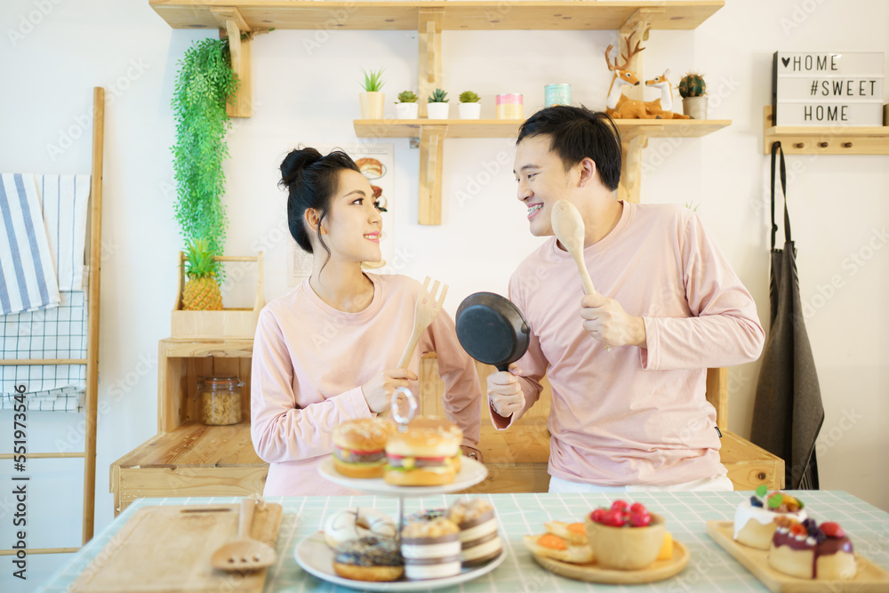 Happy young couple cooks a breakfast together in kitchen, romantic Asian young couple cooking a breakfast in the morning. Happy young couple cooks a breakfast together in kitchen, romantic Asian young couple cooking a breakfast in the morning.