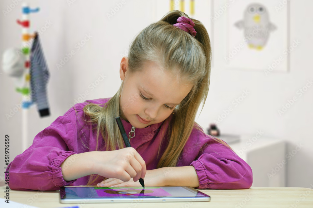 A pretty happy little girl drawing with digital tablet at home. A pretty happy little girl drawing with digital tablet at home.