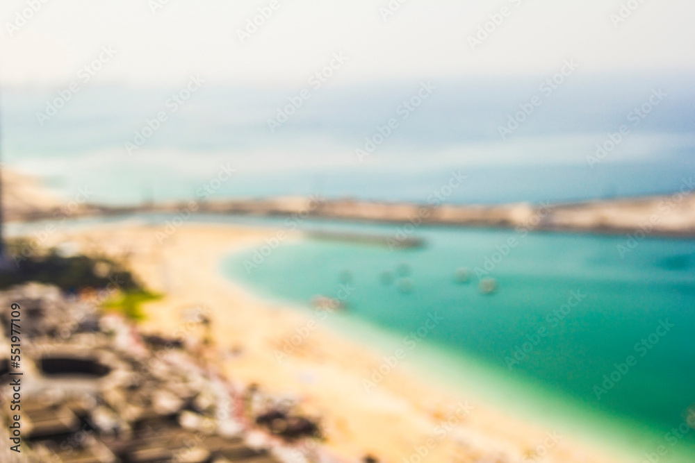 photo background blurred coast of Jumeirah Beach Resort with the beach and water of the Persian Gulf during the day in sunny weather, Dubai