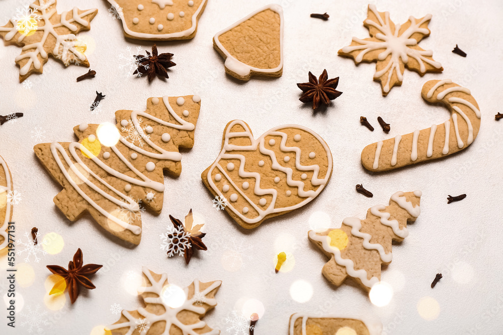 Different Christmas cookies and spices on light background