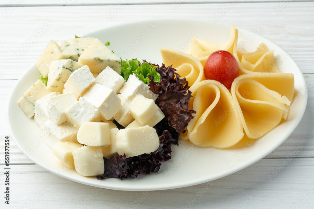 Assortment of cheese on a white plate Assortment of cheese on a white plate