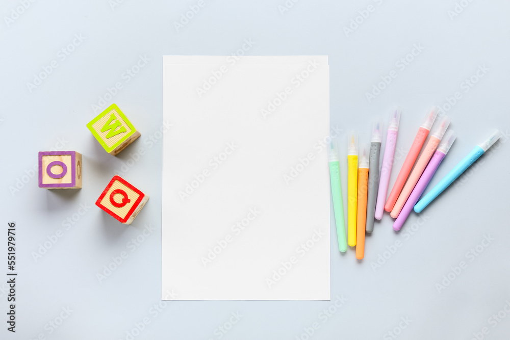 Blank paper sheet with felt-tip pens and cubes on light background Blank paper sheet with felt-tip pens and cubes on light background
