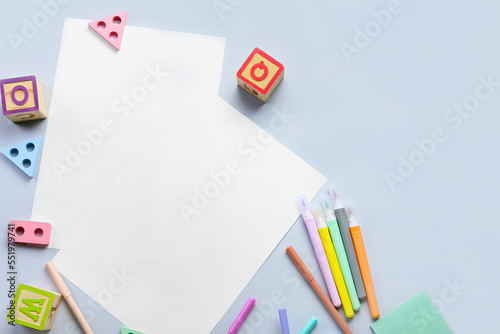 Blank paper sheets with felt-tip pens and educational toys on light background