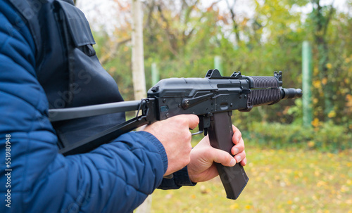 A man holds a Kalashnikov assault rifle in his hands for firing from the hip