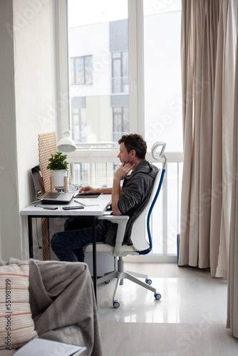 young male student working on the computer at home, home office, online learning