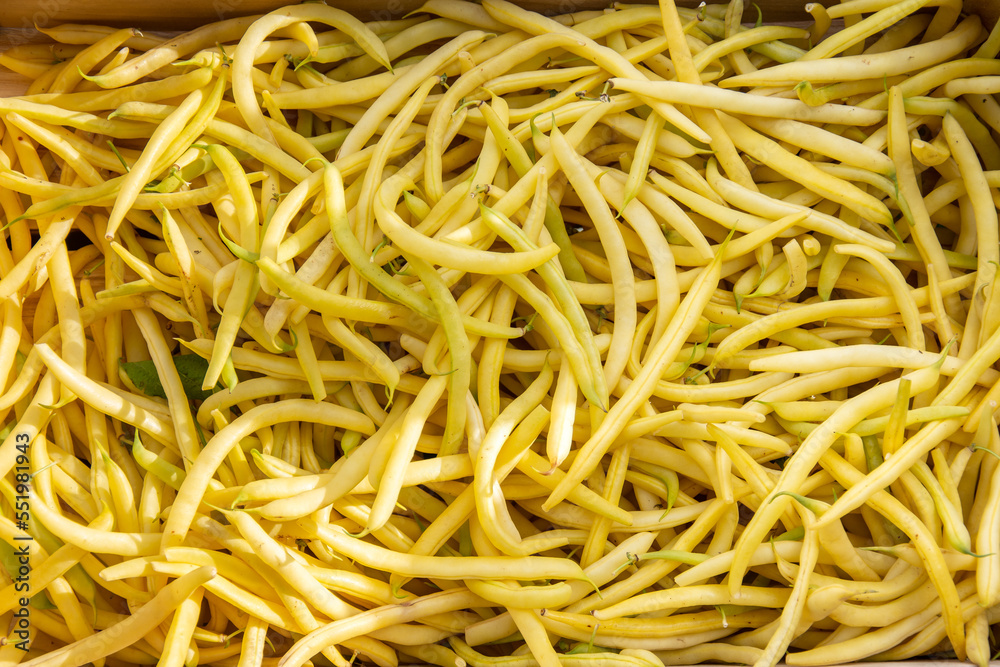 a wooden crate of yellow raw beans at an autumn fair