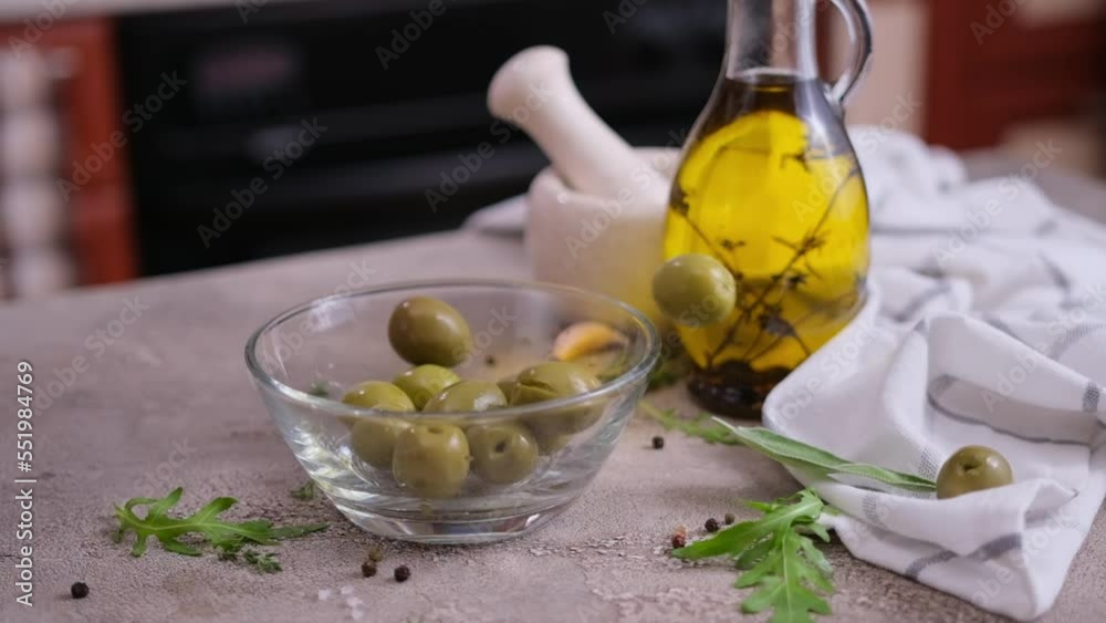 Green Pickled Olives falling into glass bowl at domestic kitchen Green Pickled Olives falling into glass bowl at domestic kitchen
