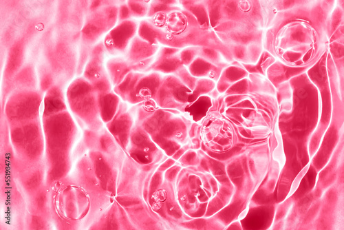 Textured background of magenta rippled water with bubbles