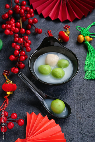 Bowl of tangyuan and Chinese decor on dark background. Dongzhi Festival