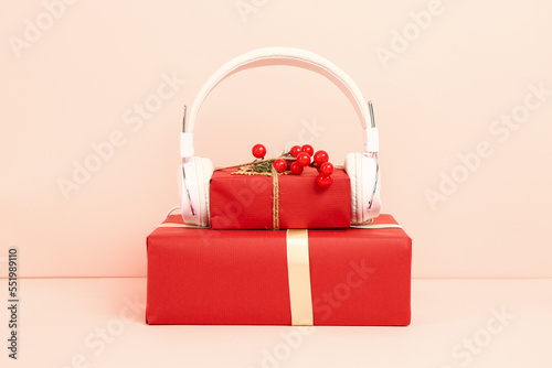 Headphones with Christmas gifts on pink background
