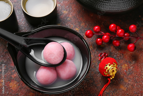 Konstfotografi Spoon and bowl of tangyuan with Chinese decor on grunge background, closeup