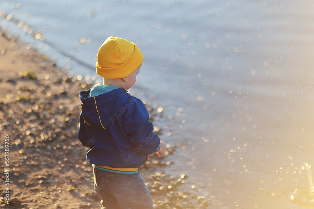 boy throws stones into the water