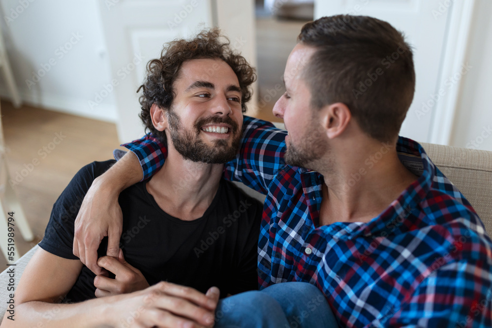 Loving Same Sex Male Gay Couple Lying On Sofa At Home And Relaxing, cuddling Together Loving Same Sex Male Gay Couple Lying On Sofa At Home And Relaxing, cuddling Together