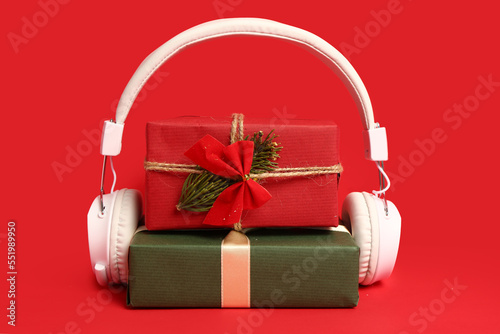 Headphones with Christmas gifts on red background