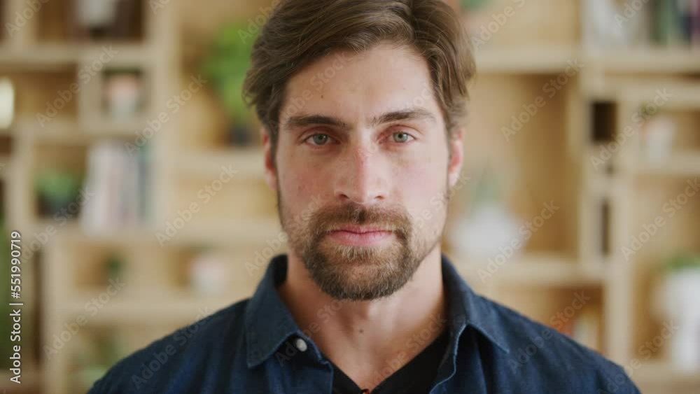 Man, face and serious expression against a blur background with front portrait with green eyes and beard. Identity of a business leader taking a deep breath while standing indoors in a creative space Man, face and serious expression against a blur background with front portrait with green eyes and beard. Identity of a business leader taking a deep breath while standing indoors in a creative space