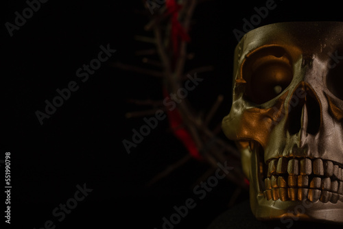 Skull of a person with crown of thorns close up on a black background