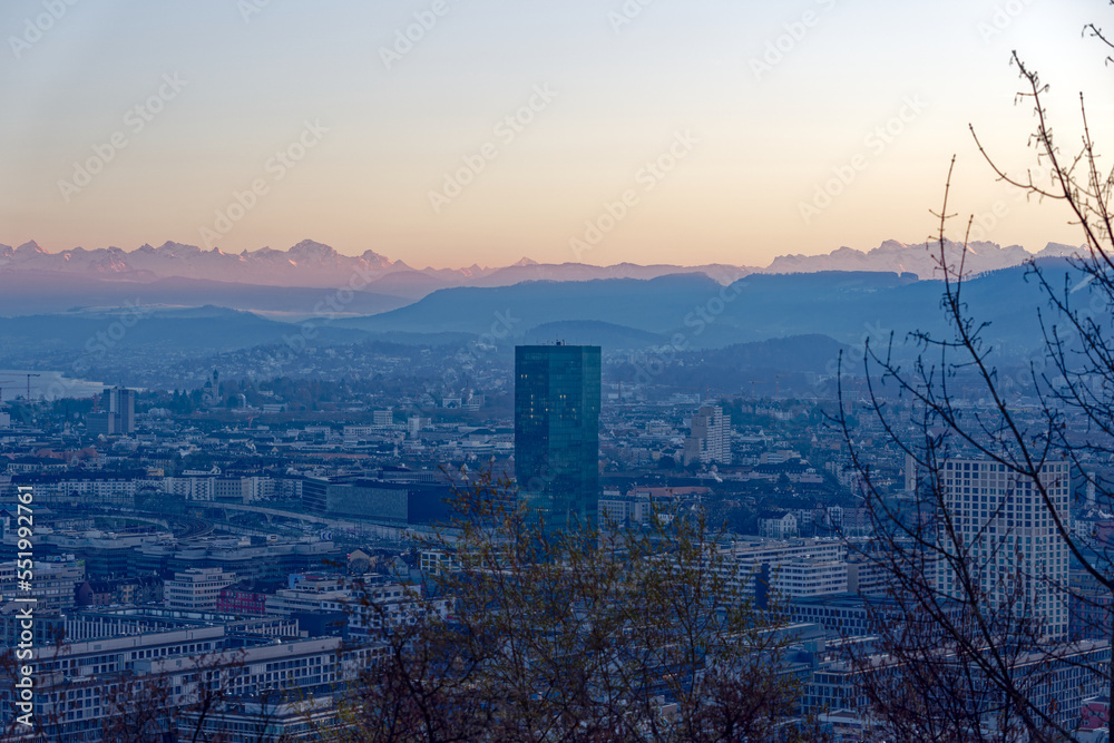 Aerial view over City of Zürich with skyscraper Prime Tower and Swiss Alps in the background on a sunny autumn evening. Photo taken December 6th, 2022, Zurich, Switzerland.