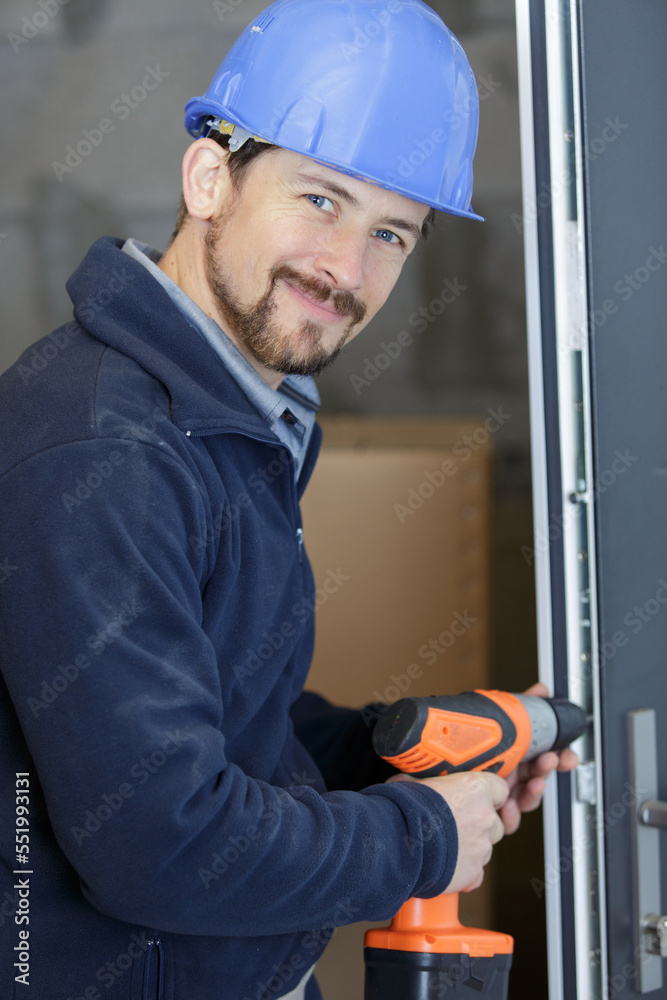 construction worker using cordless drill on door frame construction worker using cordless drill on door frame