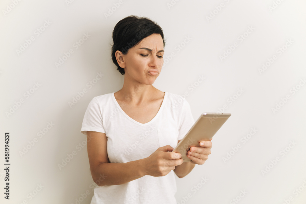 Woman looking to tablet. Slim brunette with short hair isolated on white Woman looking to tablet. Slim brunette with short hair isolated on white