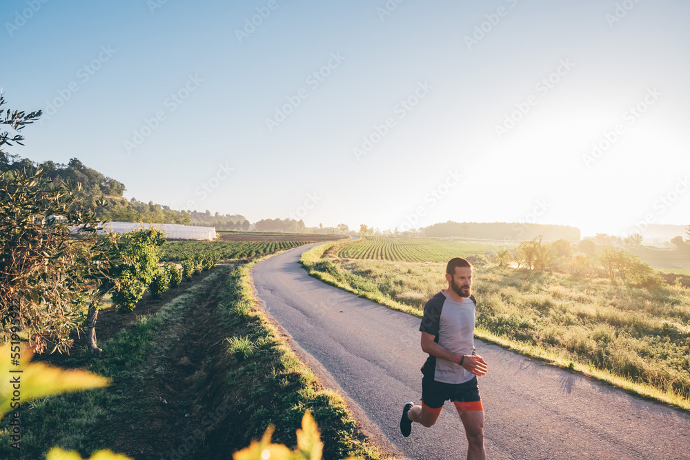 Fototapeta premium Man running in the countryside at sunrise