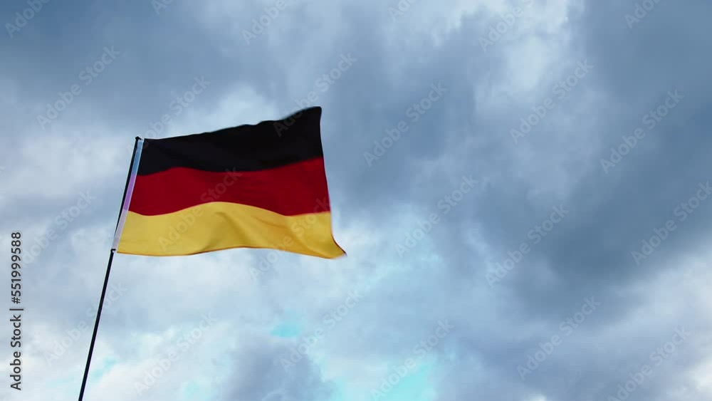 Real german flag waving in cloudy day sky Real german flag waving in cloudy day sky