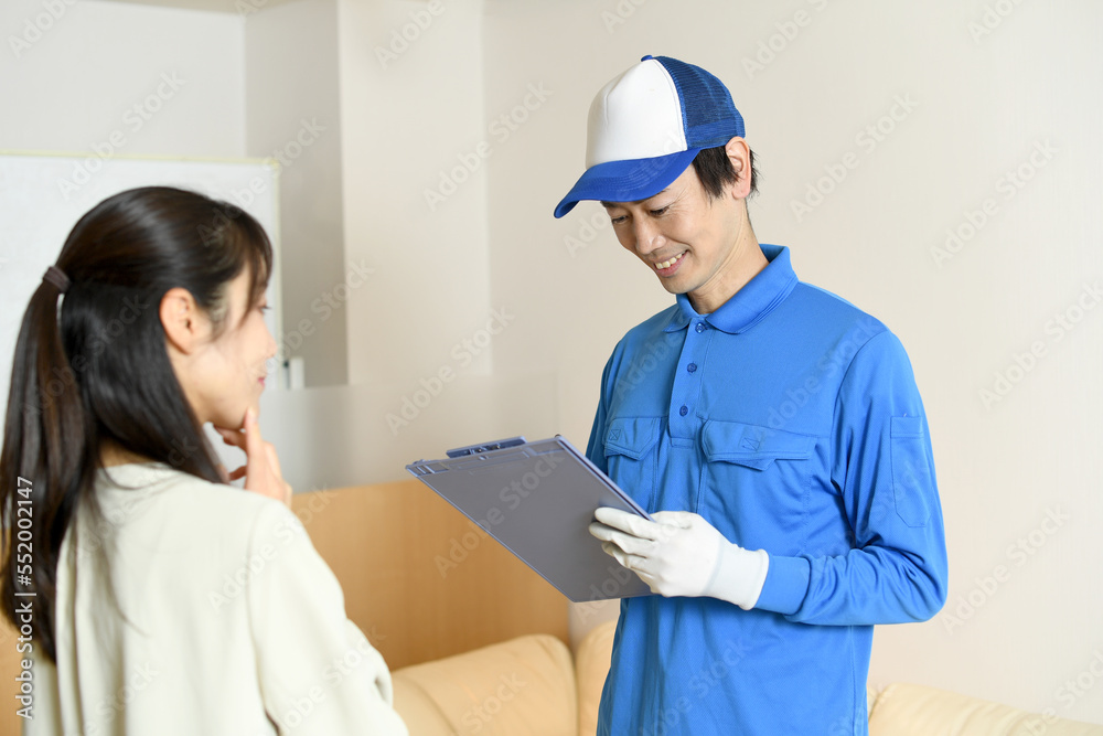 会話をする作業員の男性と若い女性