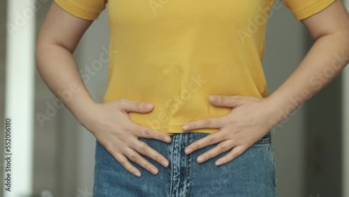 Woman touching his stomach. Stomach pain and others stomach disease concept.Girl having a stomachache. Young woman suffering from abdominal pain. Woman Stomach Ache. photo