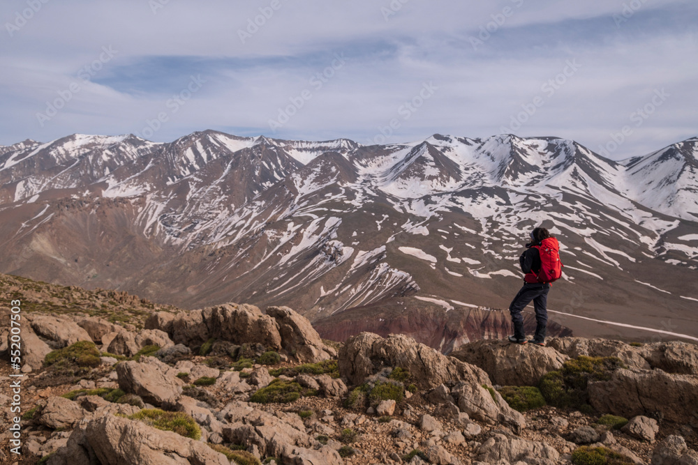 woman hiker on Aghouri ridge observing the M Goun mountain range, 4068mts, Atlas mountain range, morocco, africa